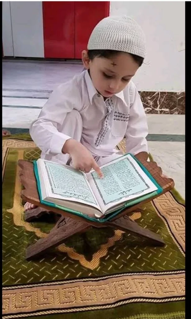Young Child Reading the Holy Quran on a Prayer Mat